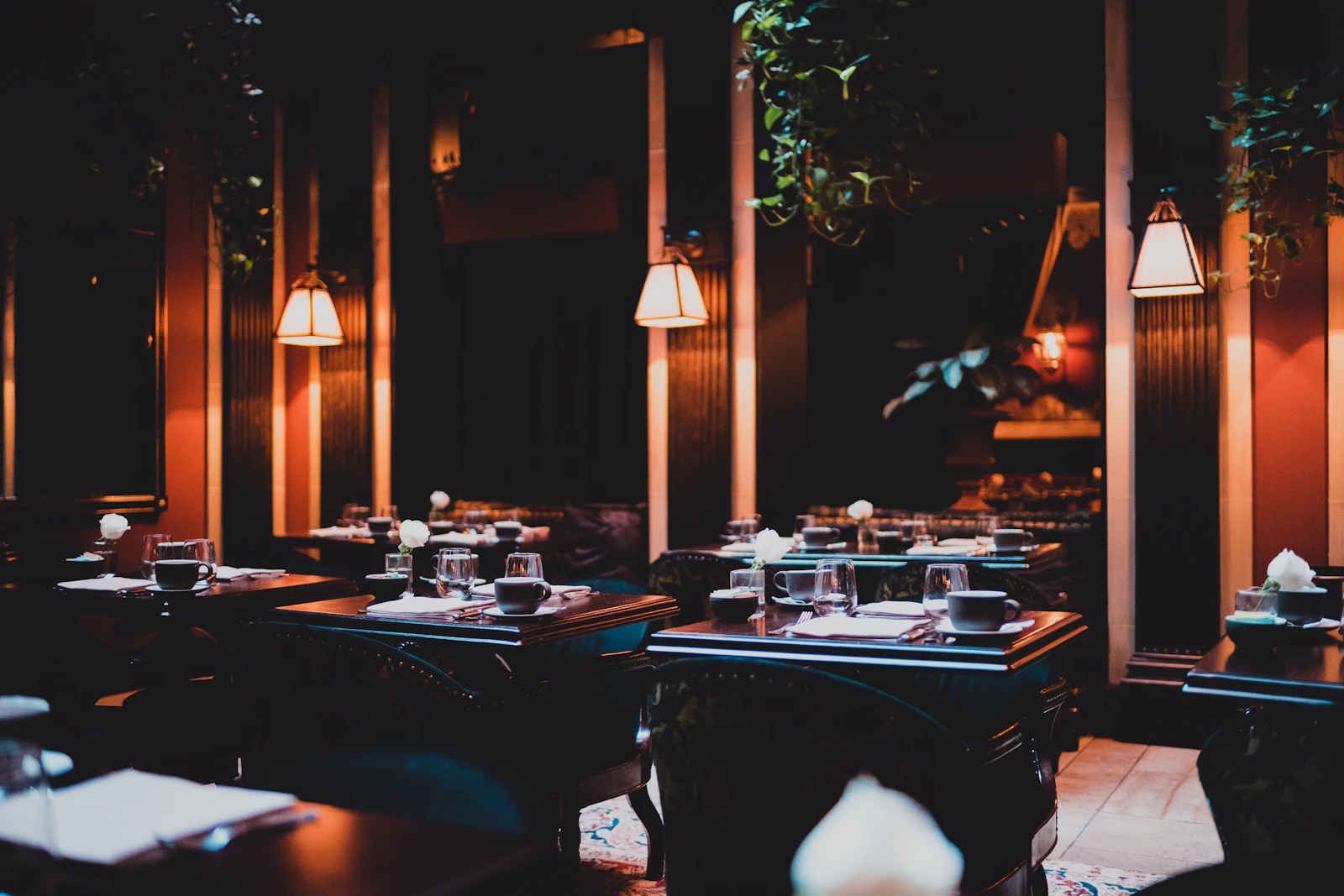 Salonul restaurantului seara, cu lumini calde deasupra meselor